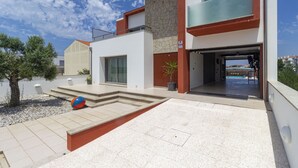 Um edifício moderno com piscina, área de estar externa e céu claro.
