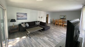 Moderni olohuone, jossa on sohva, sohvapöytä ja ruokailutila.