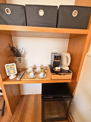 A compact kitchenette with a coffee maker, tea set, and a small refrigerator. - Naval Vila do Conde (Vila do Conde)