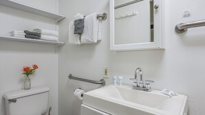 Une salle de bain équipée de toilettes, d’un lavabo et d’un porte-serviettes.