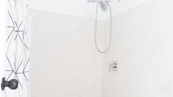Un baño con ducha, inodoro y un perchero para toallas.