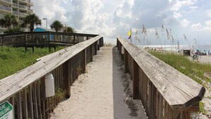 A wooden boardwalk leading to a beach with a sign indicating a dune building. - White Sands and Good Times (Orange Beach)