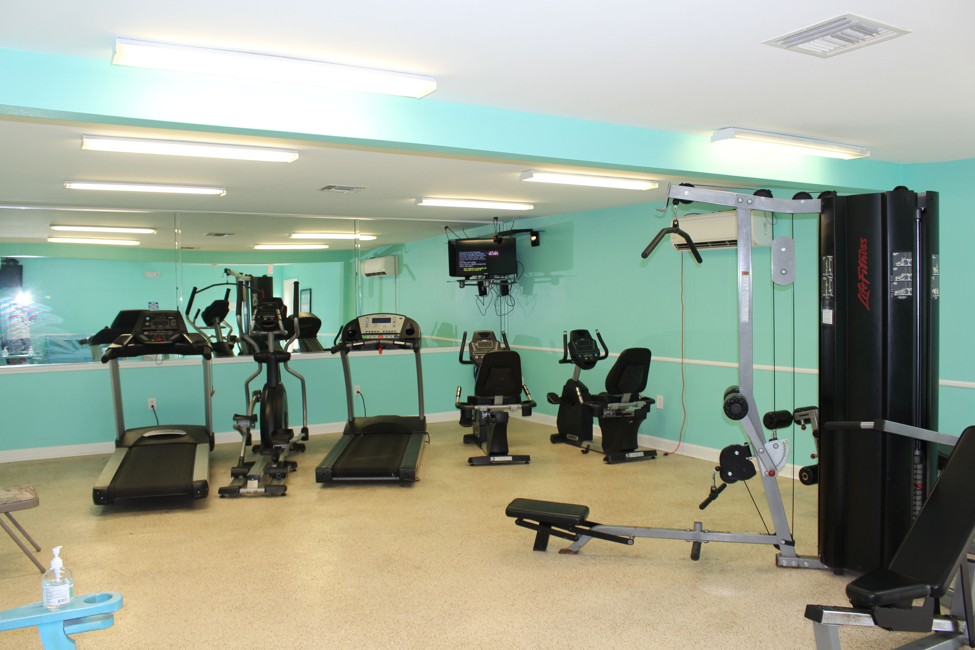 A gym with treadmills, elliptical machines, and weight equipment.