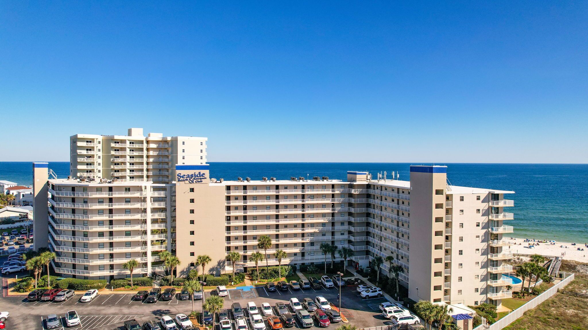Hotel aan het strand met meerdere verdiepingen, een parkeerplaats en uitzicht op de oceaan.