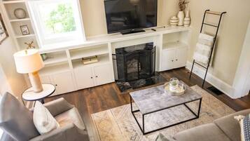 A living room with a fireplace, a television, and a coffee table.