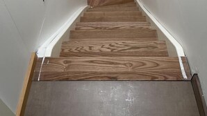 Eine Treppe mit Holzdielen und weißen Wänden.