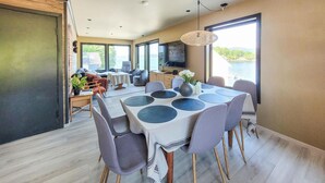 A modern dining area with a table set for four, surrounded by chairs with wooden legs.