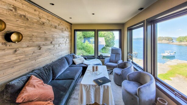 A modern interior with a wooden wall, a sofa, armchairs, and a table.