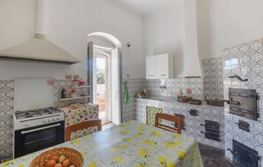 Enjoy cooking in this well-equipped kitchen with a gas stove and oven, dining area, and access to an outdoor space.