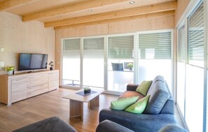 Relax in this stylish living room with a flat-screen TV, comfortable sofa, and a potted plant on the coffee table.