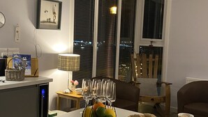 A dining area with a large table set for a meal, featuring a variety of cheeses, meats, and fruits. - FOINAVEN HOUSE, Quality 4 star self catering accommodation with panoramic views. (Ullapool)
