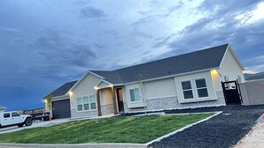 A single-story house with a garage, a driveway, and a well-maintained lawn. - 3 Peaks Mountain View Getaway w/Hot Tub! (Cedar City)