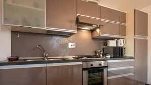 Een moderne keuken met roestvrijstalen apparatuur, een inbouwoven en een magnetron.