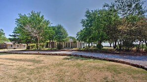 A residential property with a well-maintained lawn, a stone pathway, and mature trees. - Lovely Pottsboro Home w/ Patio & Fire Pits! (Pottsboro)