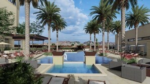 A resort pool area with lounge chairs, palm trees, and a mountain backdrop. - Hilton North Scottsdale At Cavasson (Scottsdale)