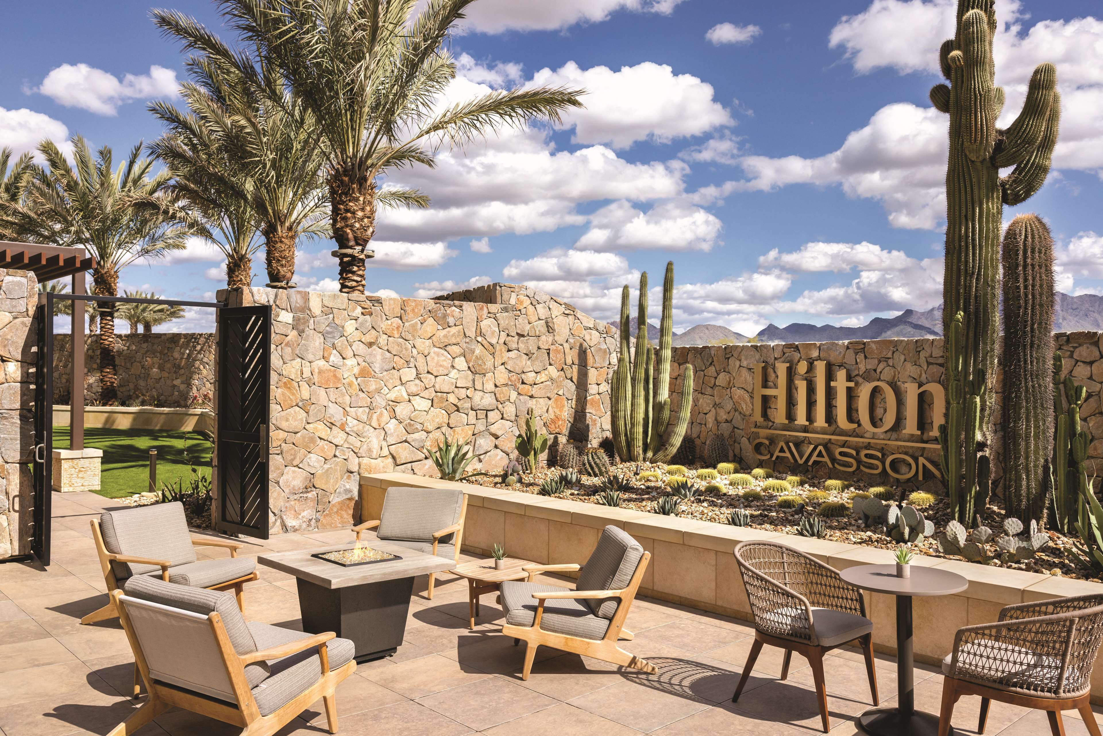 A patio area with outdoor furniture, a stone wall, and a cacti garden.