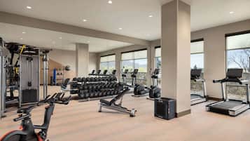 A modern gym with cardio machines, weightlifting equipment, and ample natural light.