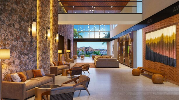 A spacious lobby with stone walls, comfortable seating, and a large window offering a mountain view.