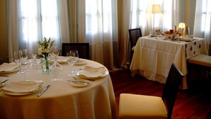 A dining area with round tables set for a meal, featuring white tablecloths and glassware. - Hotel Arcea Palacio de las Nieves (Oviedo)