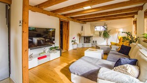 A spacious living room with wooden beams, a flat-screen TV, a fireplace, and a cozy seating area with a sofa and armchairs. - Beautiful home in Czarny Mlyn with WiFi (Czarny Mlyn)