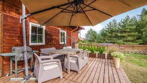 A wooden deck with outdoor furniture, a grill, and a large umbrella. - Beautiful home in Czarny Mlyn with WiFi (Czarny Mlyn)