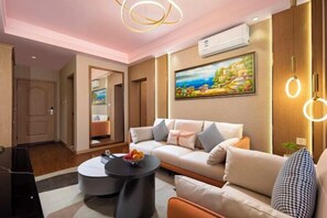 A modern living room with a sofa, coffee table, and artwork on the wall.