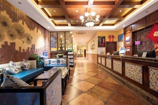 A hotel lobby with a reception desk, seating area, and decorative wall panels. - Ronhuw Garden Hotel (Chengdu)