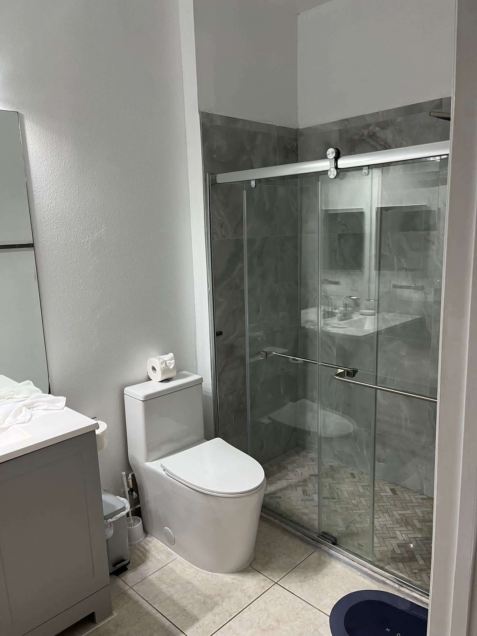 Un baño moderno con inodoro, cabina de ducha y lavamanos.