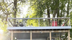 A wooden structure with a balcony, labeled "GRANDAS," featuring outdoor seating and a staircase. - Experience Pokegama charm in our cozy 3 bedroom cabin. (Grasston)