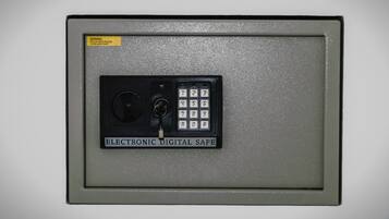 An electronic safe with a keypad and a warning label.