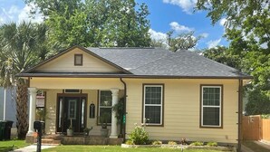 Une maison de plain-pied avec un porche à l’avant, une boîte aux lettres et un petit jardin.