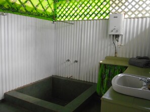 Chuveiro, toalhas de banho, sabonete, papel higiênico