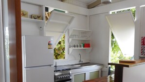 Une cuisine de taille réduite, avec des meubles blancs, une cuisinière et un évier.