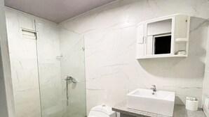 A modern bathroom with a glass-enclosed shower, a white toilet, a sink with a countertop, and a cabinet. - RA-4 cómodo apartamento con vista al mar (Samaná)