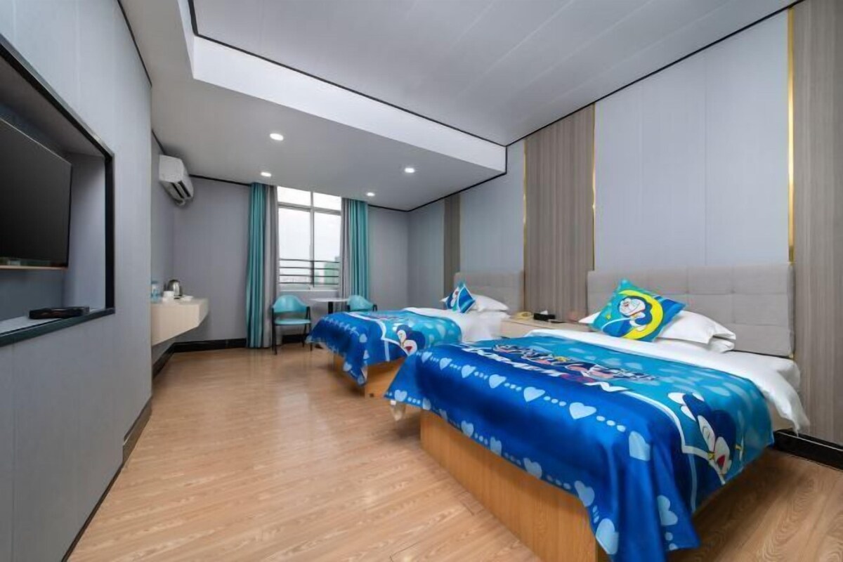Une chambre d’hôtel avec deux lits, un bureau, une chaise et une grande fenêtre.