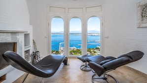 Una habitación con vista al mar, que incluye dos sillones reclinables y una chimenea.