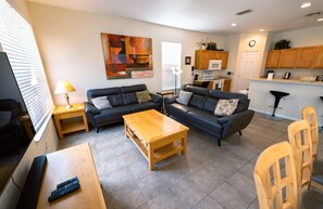 Relax in this stylish living room with a sofa, coffee table, and TV, plus a fully equipped kitchen area.