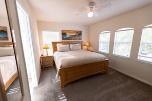 A bedroom with a wooden bed, two bedside tables with lamps, a ceiling fan, and three windows with blinds. - 4BR spacious, luxury villa • Nr Disney, private spa & pool • Games Room (Davenport)
