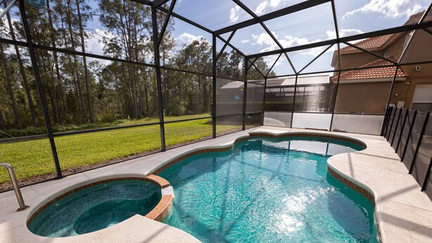 Uma piscina com design curvo, cercada por um revestimento de vidro.