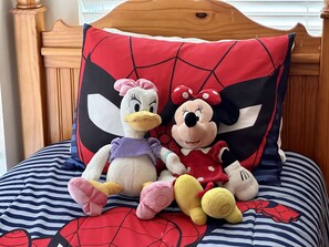 Cozy bed features a Spider-Man pillow and plush toys, including a duck and Minnie Mouse.