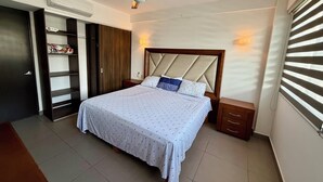 Un dormitorio con cama, ventilador de techo, armario y ventana con persianas.
