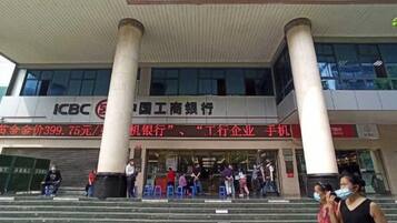 A bank entrance with columns, a signboard, and people entering.