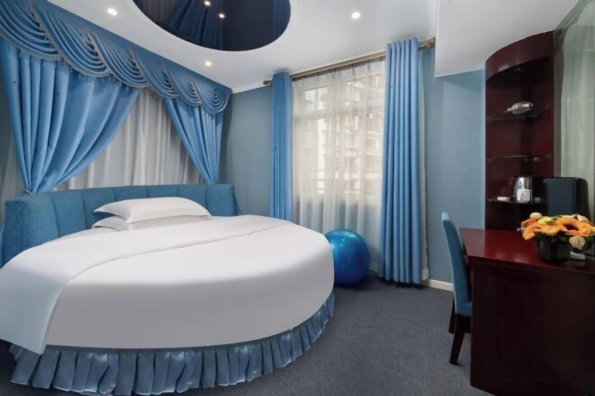 A bedroom with a bed, a desk, and a chair.