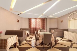 A dining area with checkered tablecloths, brown sofas, and a patterned floor. - Shangdu Hotel (Chongqing)