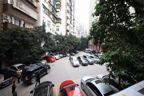 A street view with parked cars and tall buildings. - Shangdu Hotel (Chongqing)