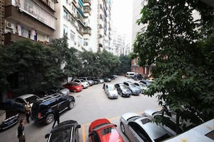 Vista da rua com carros estacionados e edifícios altos.