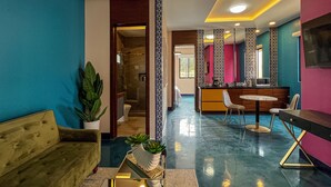 Un moderno vestíbulo de hotel con mostrador de recepción, zona de estar y baño a la vista.