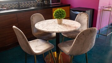 Uma cozinha moderna com mesa de mármore, quatro cadeiras e um vaso de planta.