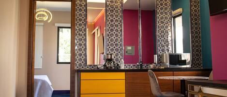A modern kitchen with a microwave, coffee maker, and a chair.