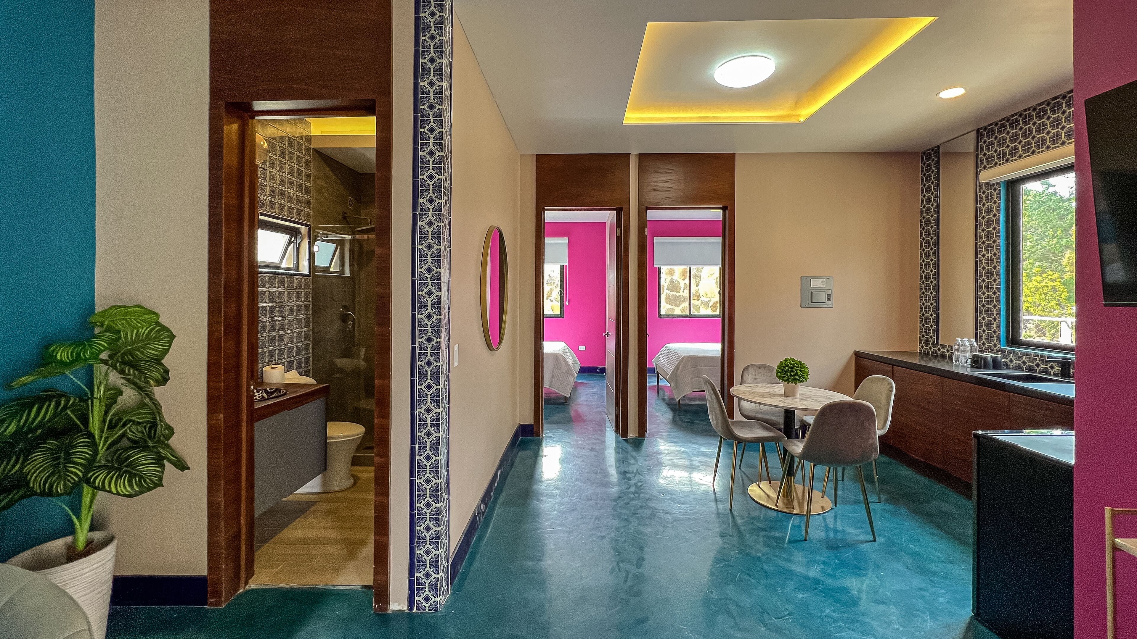 Una habitación de hotel con baño, zona de comedor y sala de estar.